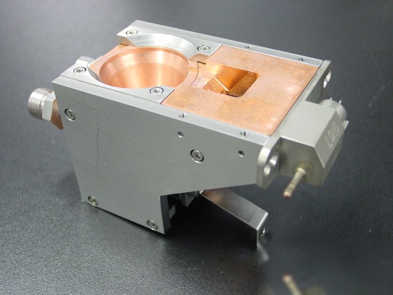 EB1 single-pocket electron-beam source: aluminium body with a water-cooled copper hearth showing one round pocket and one rectangular pocket.